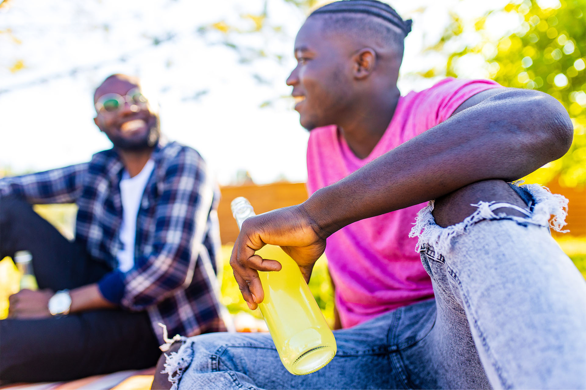 Black men enjoying drink in the park