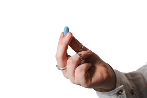 A hand holding a blue PrEP pill